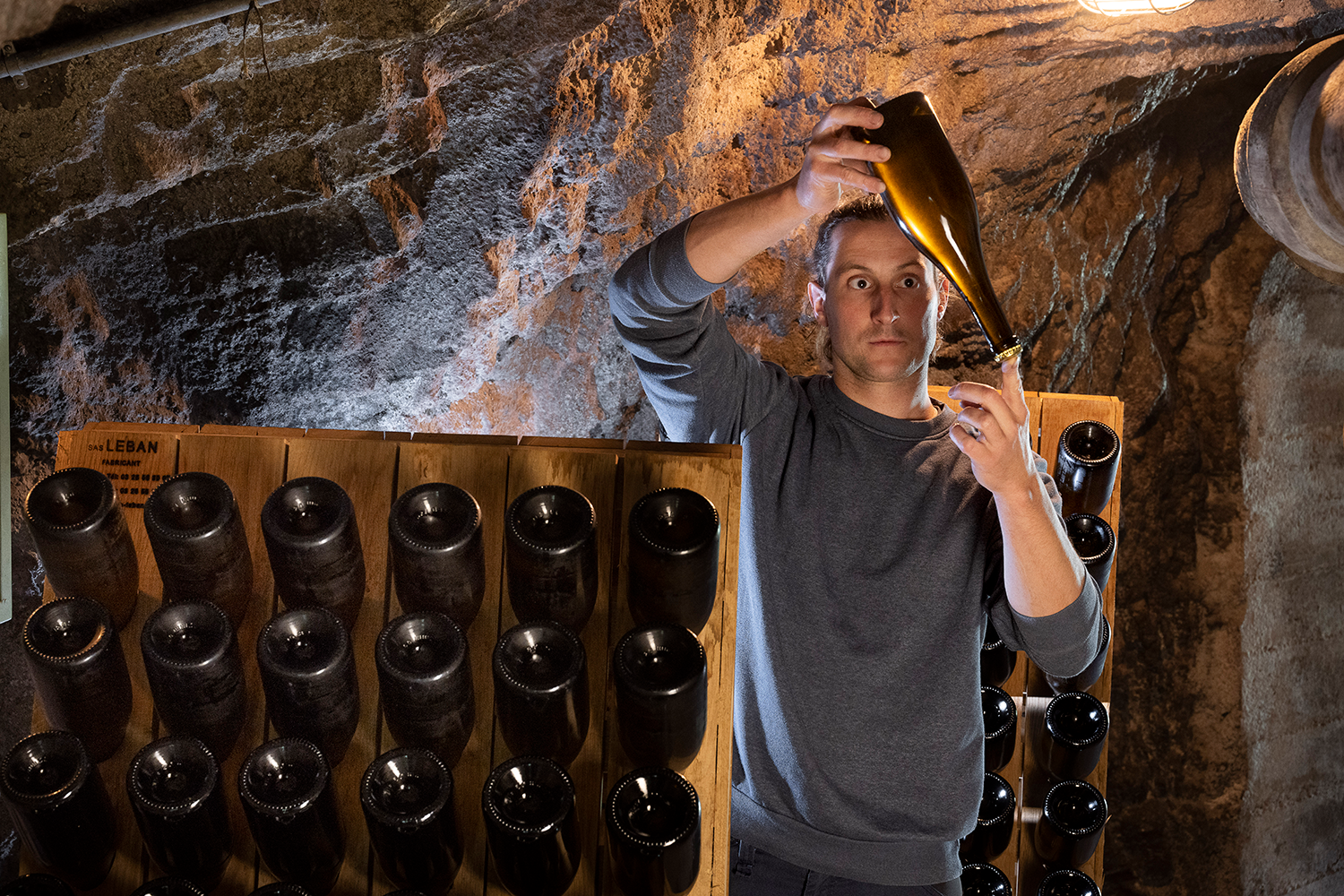05 Adank Weine - Patrick Adank Brut Patrick Adank betrachtet eine Flasche seines Schaumweins Brut - Weingut Familie Hansruedi Adank